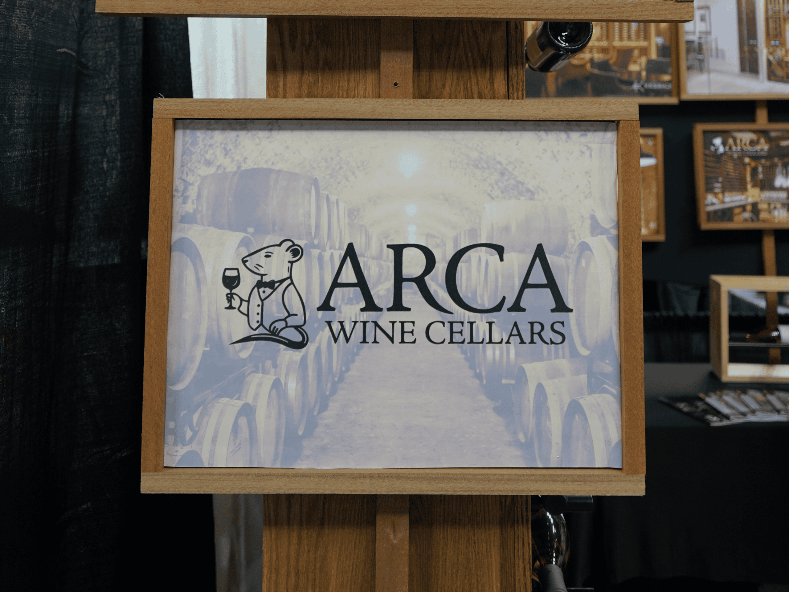 ARCA Wine Cellars Sign ARCA Wine Cellars sign with wine barrels background, showcasing wine storage expertise.
